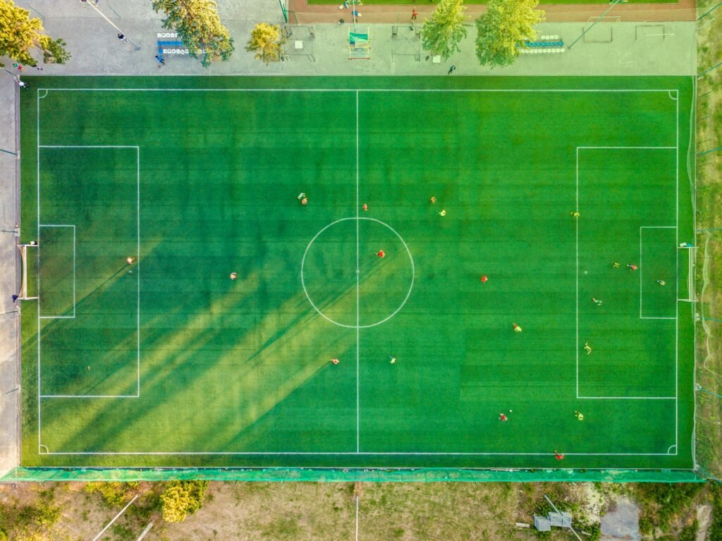 pexels photo 1171084 1171084 Aerial shot of a soccer game with players on a vibrant green field.